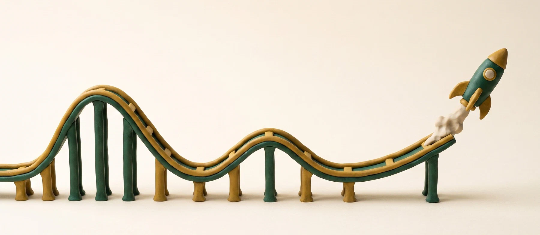 A clay rollercoaster track whose rails straighten at the far end into a rocket lifting off